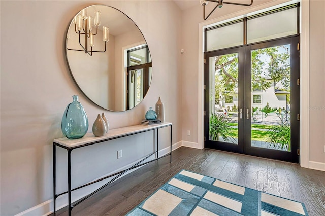 entrance foyer with french doors, baseboards, an inviting chandelier, and dark wood-style floors