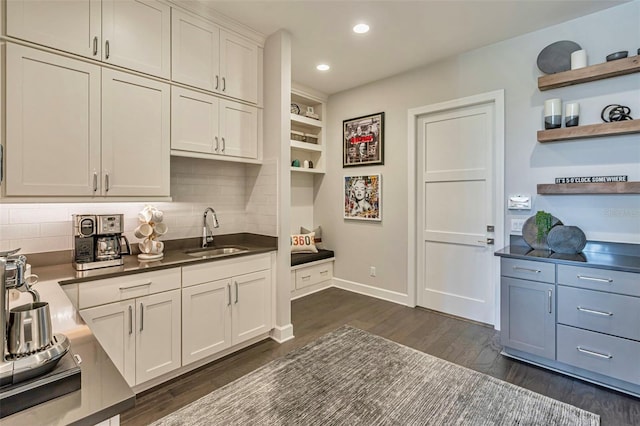 kitchen featuring tasteful backsplash, dark wood-style flooring, recessed lighting, open shelves, and a sink