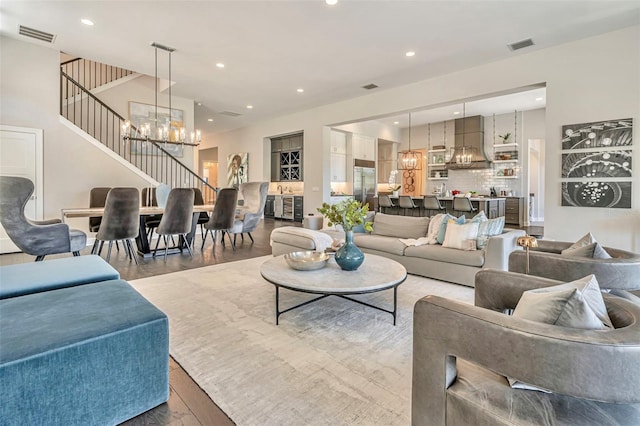 living room featuring recessed lighting, light wood-style floors, visible vents, and an inviting chandelier