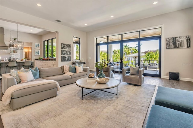 living room featuring visible vents, baseboards, recessed lighting, and light wood-style floors