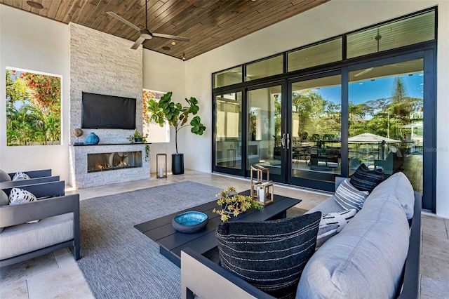 view of patio / terrace featuring an outdoor living space with a fireplace and a ceiling fan