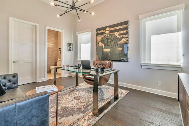 office area featuring wood finished floors, a notable chandelier, and baseboards