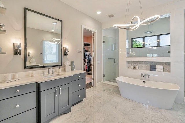 full bath with a shower stall, a freestanding tub, vanity, a spacious closet, and visible vents