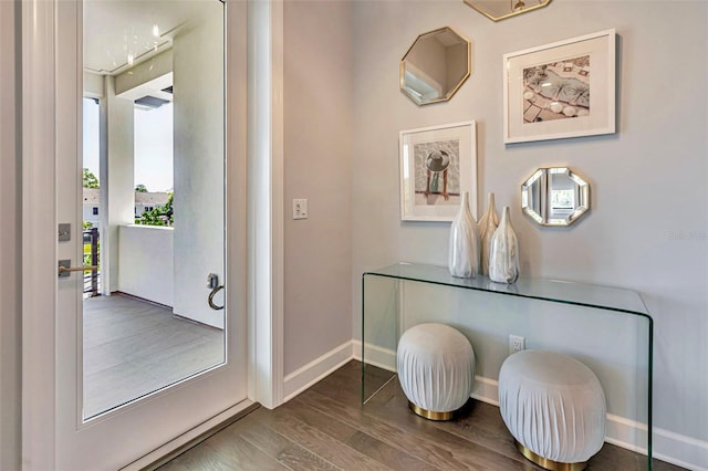 doorway to outside featuring wood finished floors and baseboards