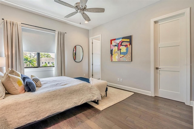 bedroom with ceiling fan, baseboards, and dark wood finished floors