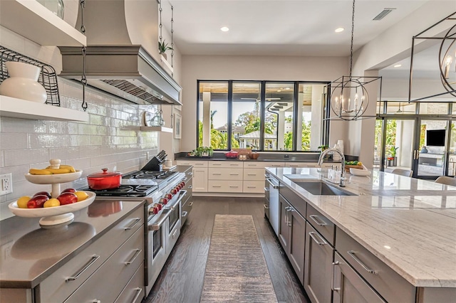 kitchen with a large island, a sink, dark wood-style flooring, double oven range, and custom range hood