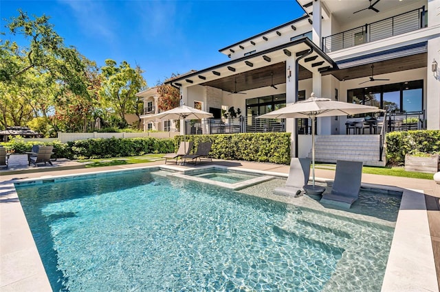 view of pool featuring a patio, a pool with connected hot tub, fence, and a ceiling fan