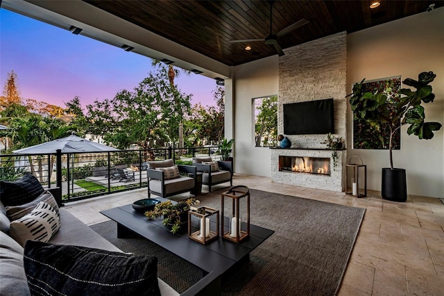 view of patio featuring an outdoor living space with a fireplace and a ceiling fan
