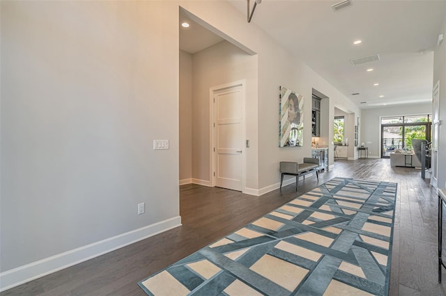 hall featuring wood finished floors, baseboards, visible vents, and recessed lighting