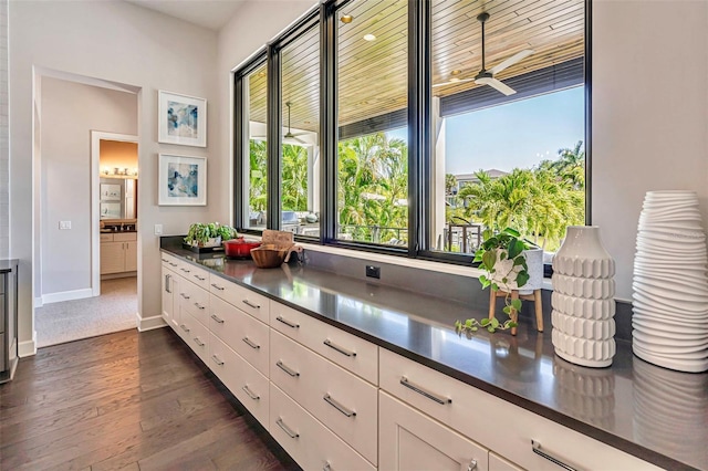 interior space featuring ceiling fan, dark countertops, white cabinets, and dark wood-style flooring