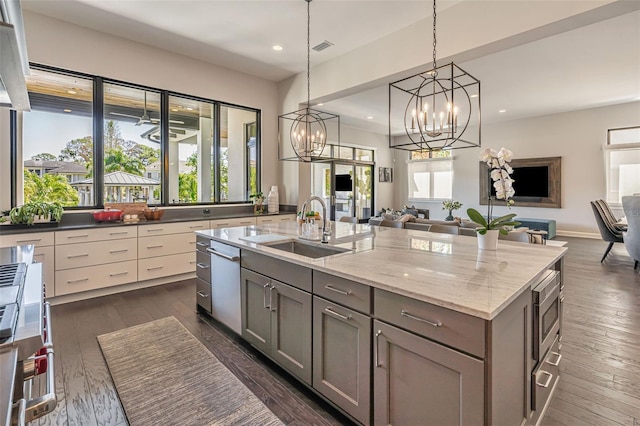 kitchen with gray cabinets, recessed lighting, open floor plan, stainless steel appliances, and a sink