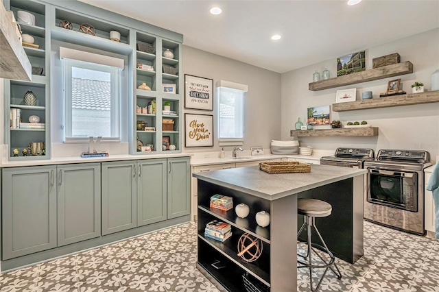kitchen featuring separate washer and dryer, a breakfast bar, light countertops, open shelves, and light floors