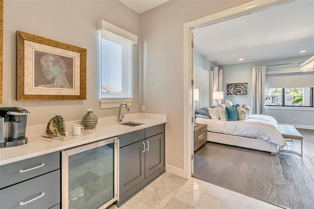 bedroom featuring baseboards, recessed lighting, beverage cooler, marble finish floor, and a sink