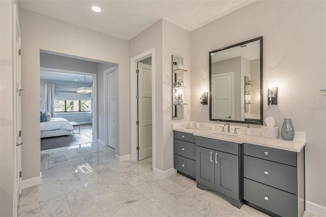 bathroom featuring marble finish floor, baseboards, and vanity