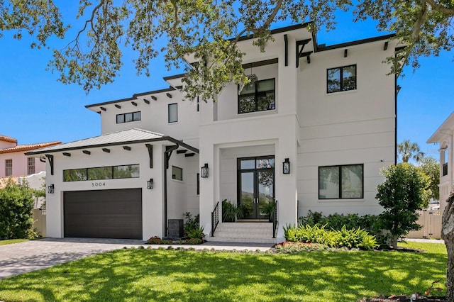 5004 S The Riviera, Tampa, FL 33609 - contemporary home featuring stucco siding, an attached garage, and a front lawn