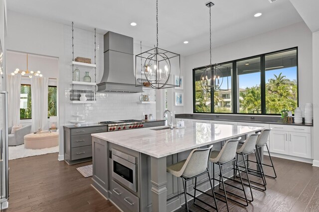 5004 S The Riviera, Tampa, FL 33609 - kitchen with gray cabinetry, appliances with stainless steel finishes, custom range hood, a chandelier, and a sink