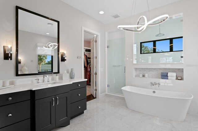 5004 S The Riviera, Tampa, FL 33609 - full bath featuring a shower stall, a walk in closet, vanity, a freestanding tub, and marble finish floors