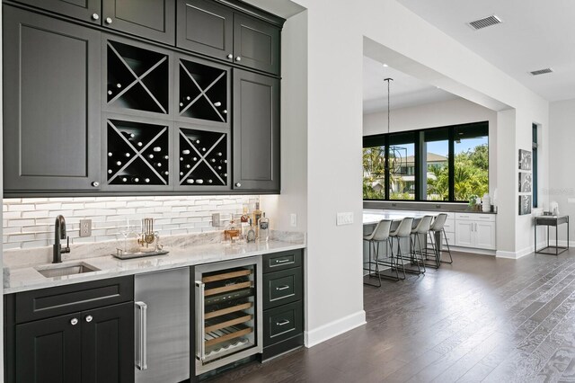 5004 S The Riviera, Tampa, FL 33609 - indoor wet bar with beverage cooler, decorative backsplash, dark wood finished floors, and baseboards