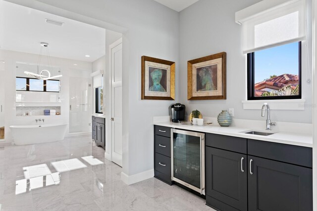 5004 S The Riviera, Tampa, FL 33609 - bar area with wine cooler, a sink, light marble finish floors, and hanging light fixtures