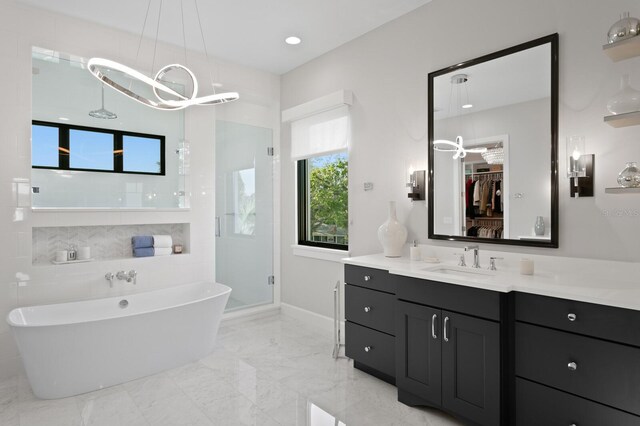 5004 S The Riviera, Tampa, FL 33609 - bathroom featuring a freestanding tub, vanity, a shower stall, a walk in closet, and marble tiled floors