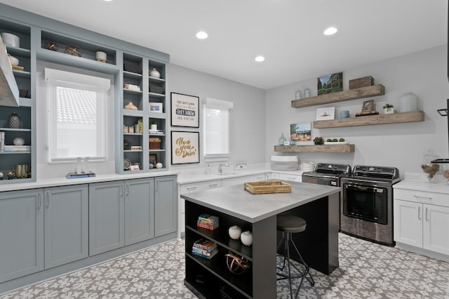 5004 S The Riviera, Tampa, FL 33609 - kitchen with open shelves, washing machine and dryer, light floors, a sink, and light countertops