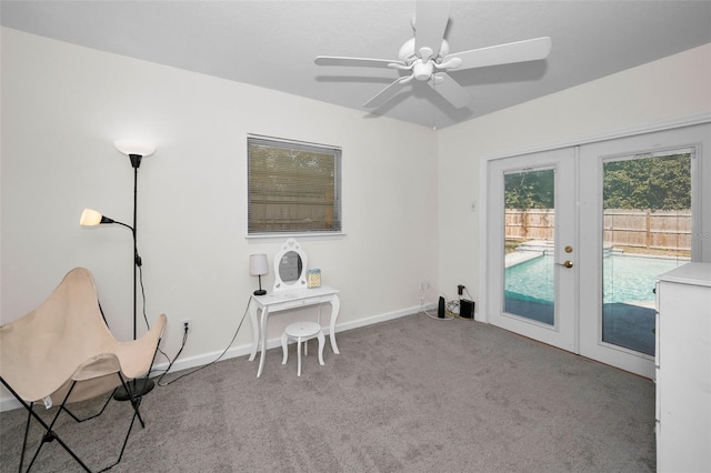 sitting room featuring french doors, light colored carpet, and ceiling fan