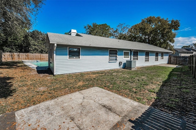 back of house with cooling unit, a yard, and a patio