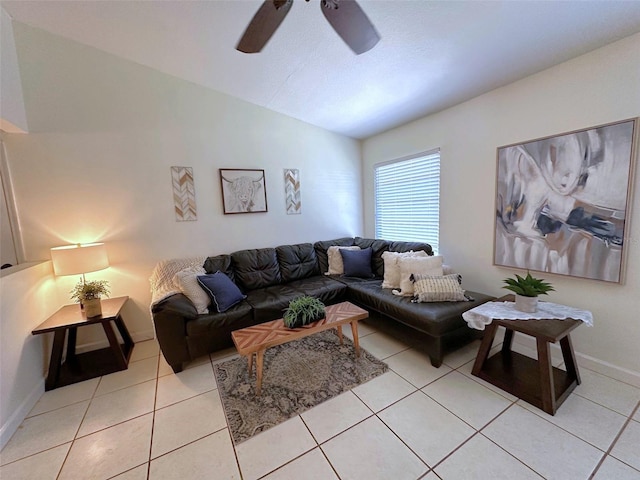 living area featuring light tile patterned floors, baseboards, a ceiling fan, and vaulted ceiling