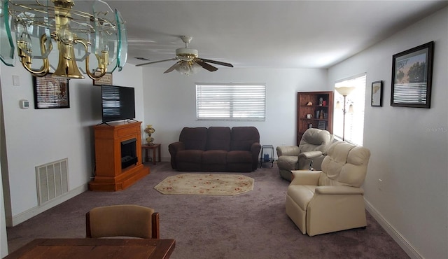 carpeted living room with baseboards, visible vents, and ceiling fan