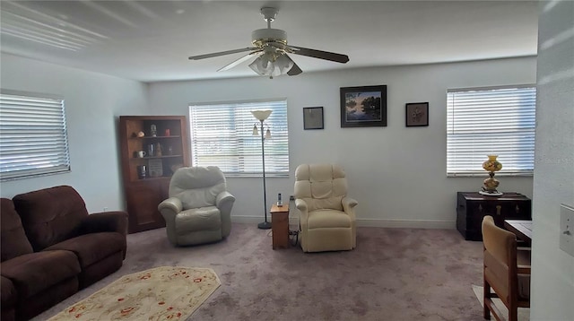 living room featuring carpet floors, a ceiling fan, and baseboards