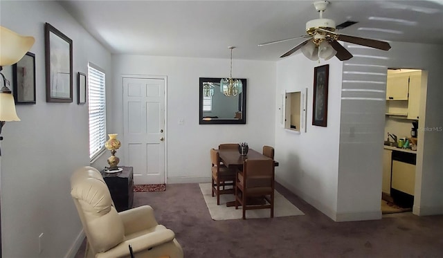 carpeted dining space with a ceiling fan and baseboards