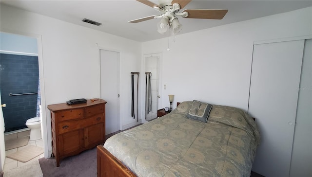 bedroom with carpet, visible vents, ceiling fan, and ensuite bath