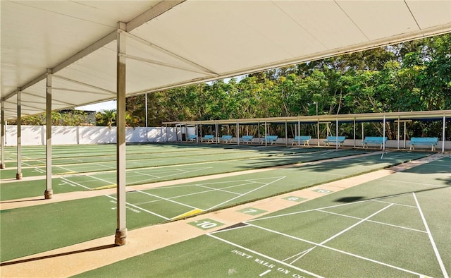 view of home's community with fence and shuffleboard