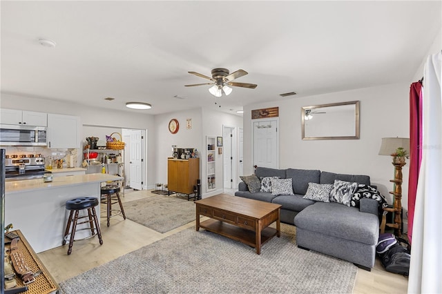 living room featuring ceiling fan and light hardwood / wood-style floors