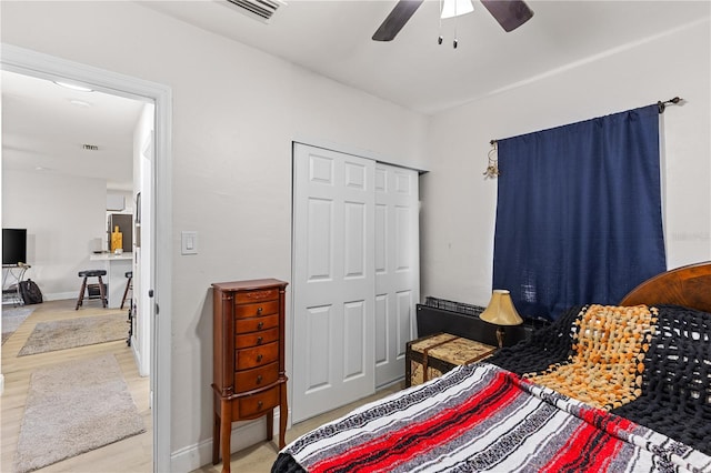 bedroom with hardwood / wood-style floors, a closet, and ceiling fan