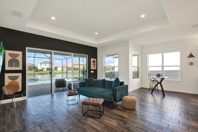 living room with visible vents, a raised ceiling, baseboards, and wood tiled floor