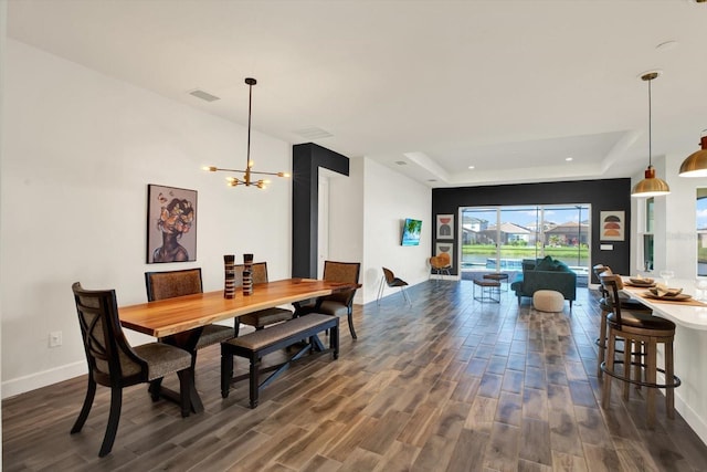 dining room featuring visible vents, dark wood-style floors, baseboards, a raised ceiling, and a chandelier