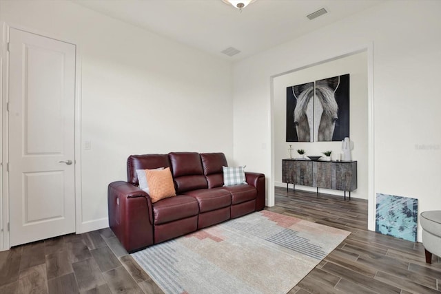 living area with visible vents, baseboards, and wood finish floors