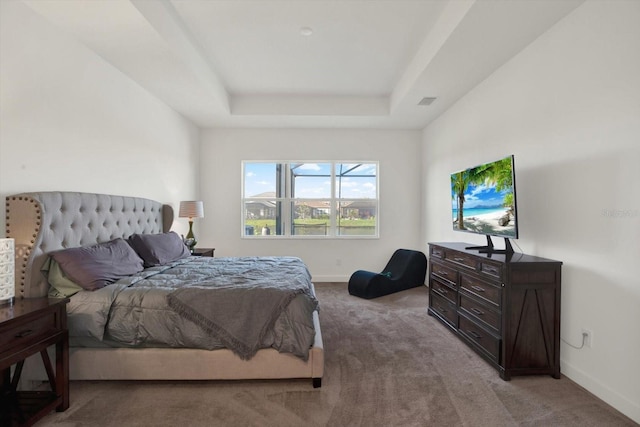 bedroom with baseboards, a raised ceiling, light colored carpet, and visible vents