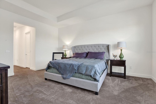 carpeted bedroom with a tray ceiling and baseboards