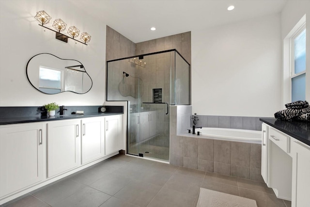 bathroom with a garden tub, a stall shower, vanity, and tile patterned flooring