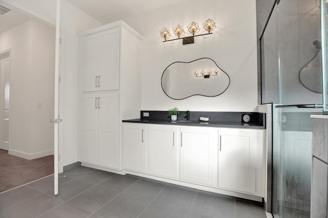 bathroom featuring tile patterned flooring, visible vents, a shower stall, and vanity