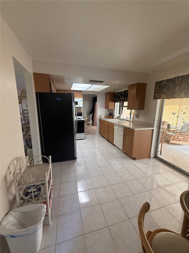 14132 89th Ave, Seminole, FL 33776 - kitchen with light tile patterned floors, light countertops, white appliances, and brown cabinets
