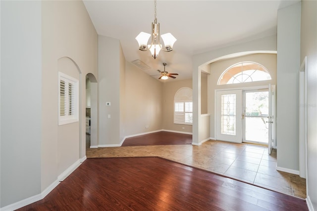 entrance foyer with ceiling fan with notable chandelier, vaulted ceiling, and wood-type flooring