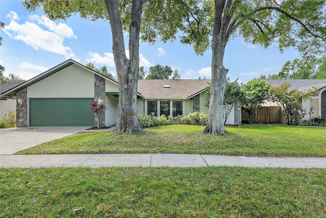 view of front of property featuring concrete driveway, a garage, a front yard, and stucco siding