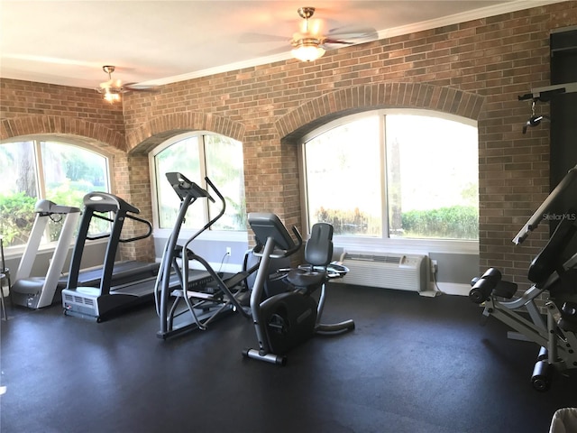 exercise room featuring crown molding, ceiling fan, and brick wall