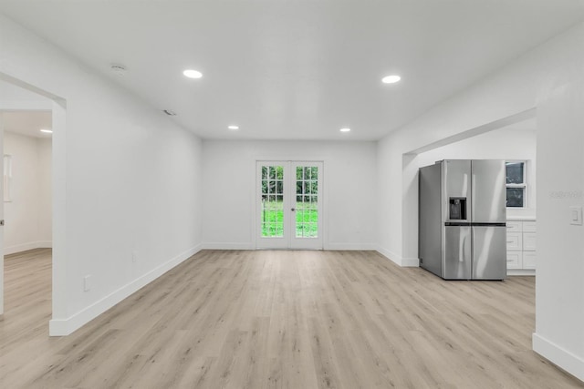 unfurnished living room with french doors and light hardwood / wood-style flooring