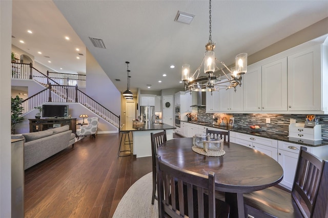 dining space with dark hardwood / wood-style floors and an inviting chandelier