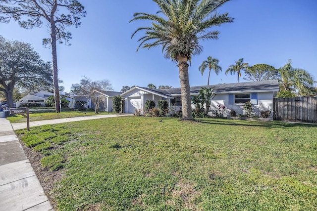 single story home featuring driveway, a garage, fence, and a front lawn