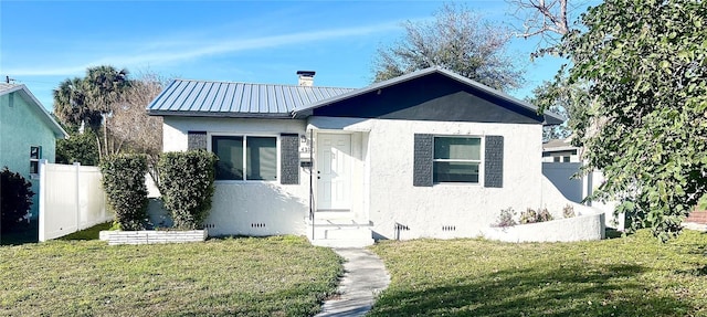 bungalow-style house with crawl space, metal roof, a front yard, and fence